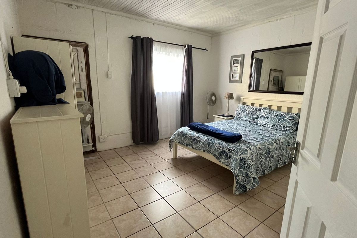 A bedroom featuring tiled flooring and a timber panelled ceiling, requiring cosmetic updates to improve the overall finish and aesthetic appeal.
