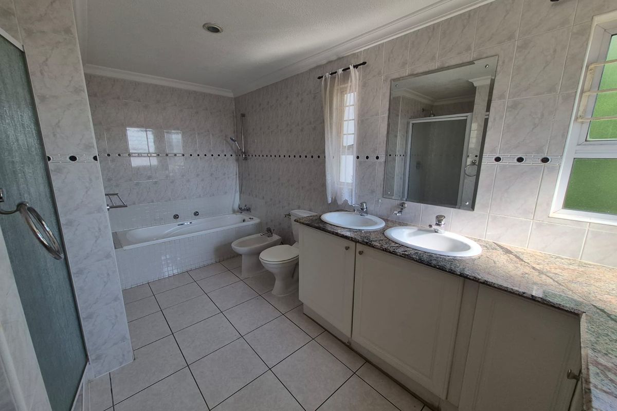 Spacious bathroom featuring a dual vanity with granite countertops, a built-in bathtub, a separate shower enclosure, and a bidet.