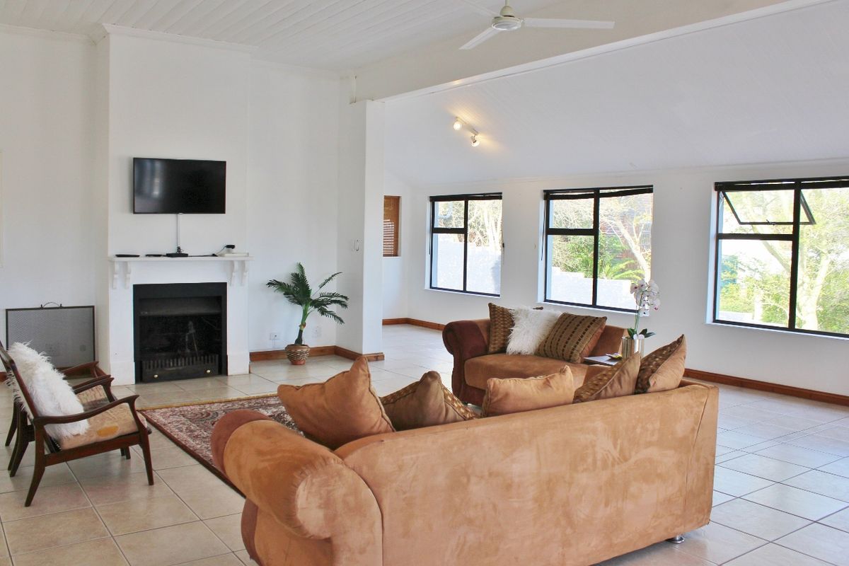 Spacious living room featuring a fireplace, tiled flooring, and large windows that provide ample natural light.