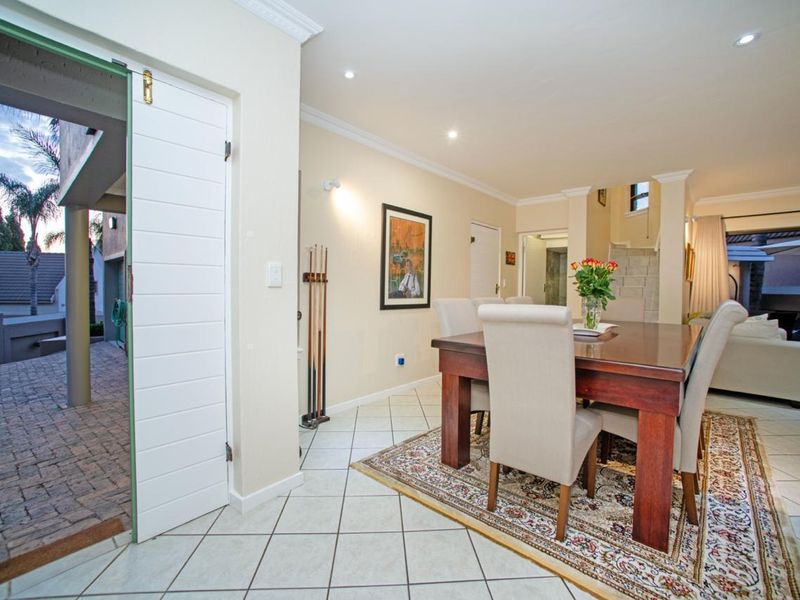 Open plan dining area featuring tiled flooring, recessed downlighting, and direct access to an outdoor patio space.