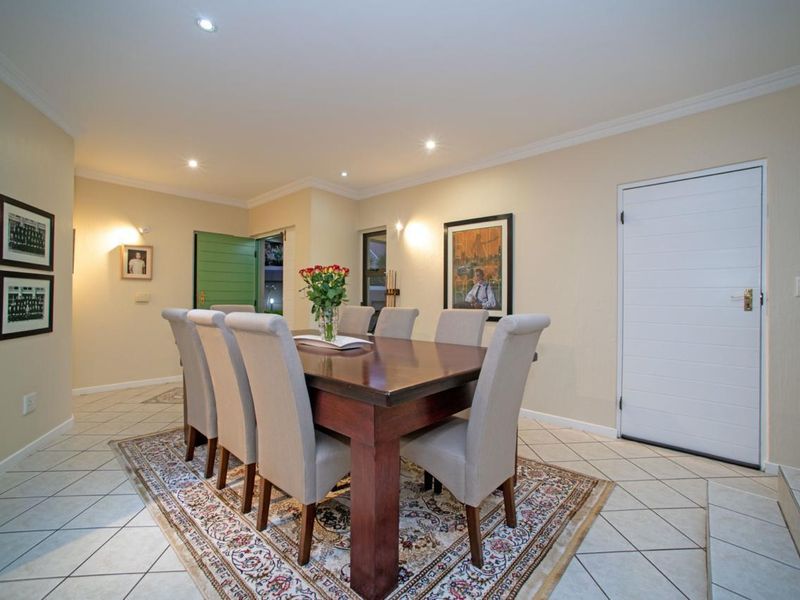 A well-lit dining area featuring tiled flooring, recessed ceiling lighting, and direct access to the exterior.