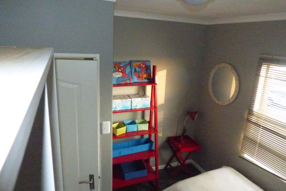 A bedroom featuring neutral wall paint, coving, and venetian blinds on the window.