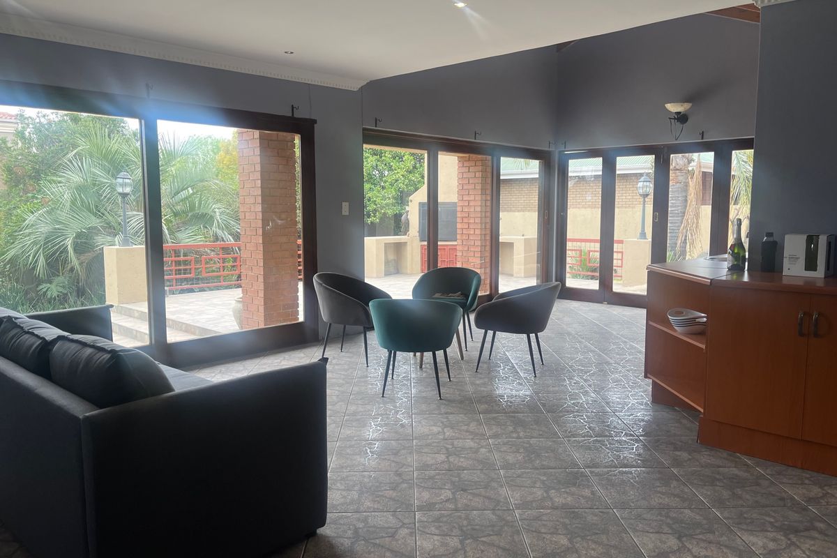 Spacious living area featuring large glass sliding doors that provide seamless access to the outdoor patio and garden area.