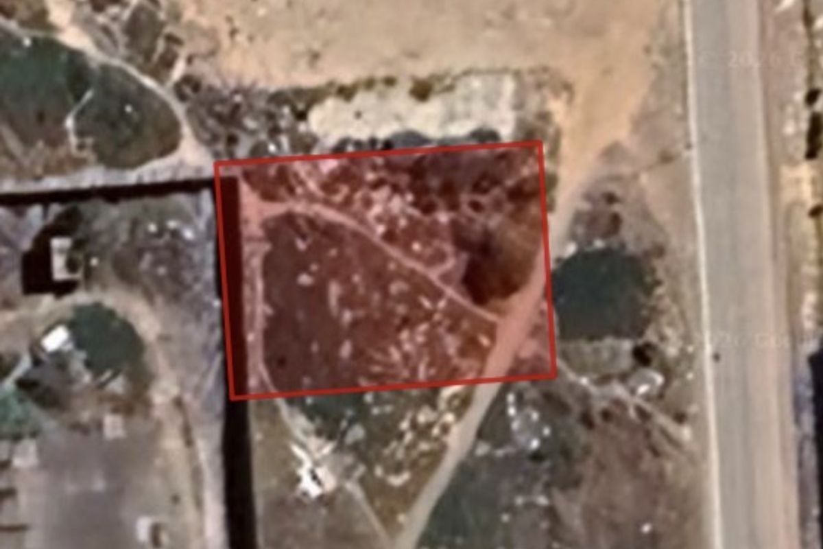 An aerial view of a vacant residential plot, highlighting the property boundaries and surrounding landscape.