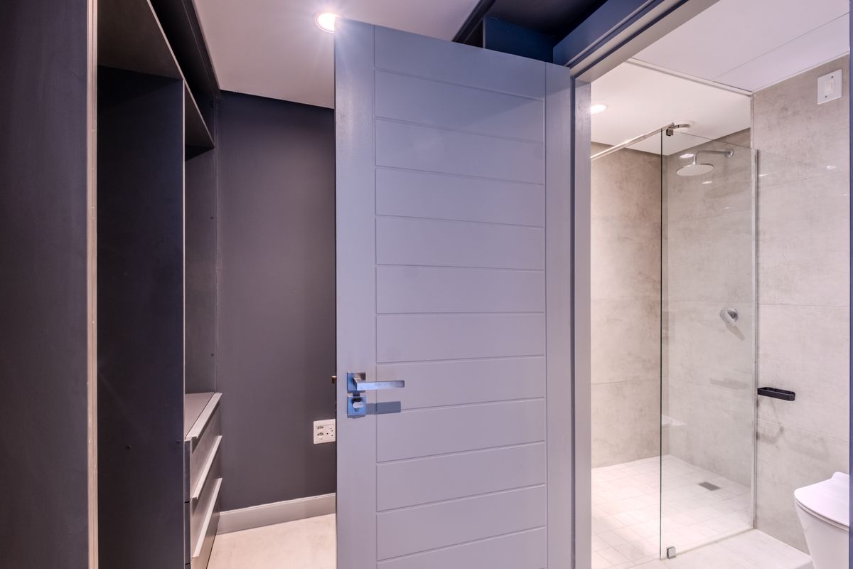 Modern bathroom featuring a glass-enclosed shower, tiled finishes, and built-in cabinetry, presenting a clean and contemporary aesthetic.