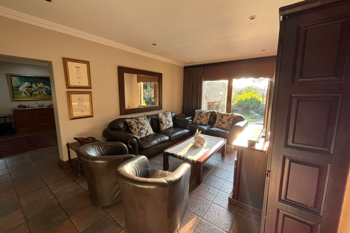 A comfortable living room featuring tiled flooring, recessed lighting, and a large sliding glass door providing access to the outdoor area.
