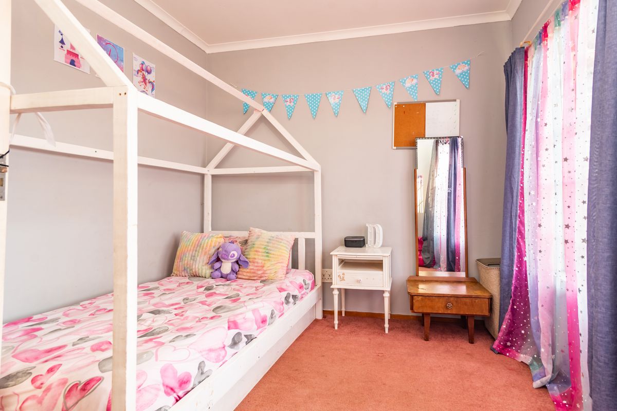 A bedroom featuring carpeted flooring and cove cornice detailing, currently styled as a child's room.