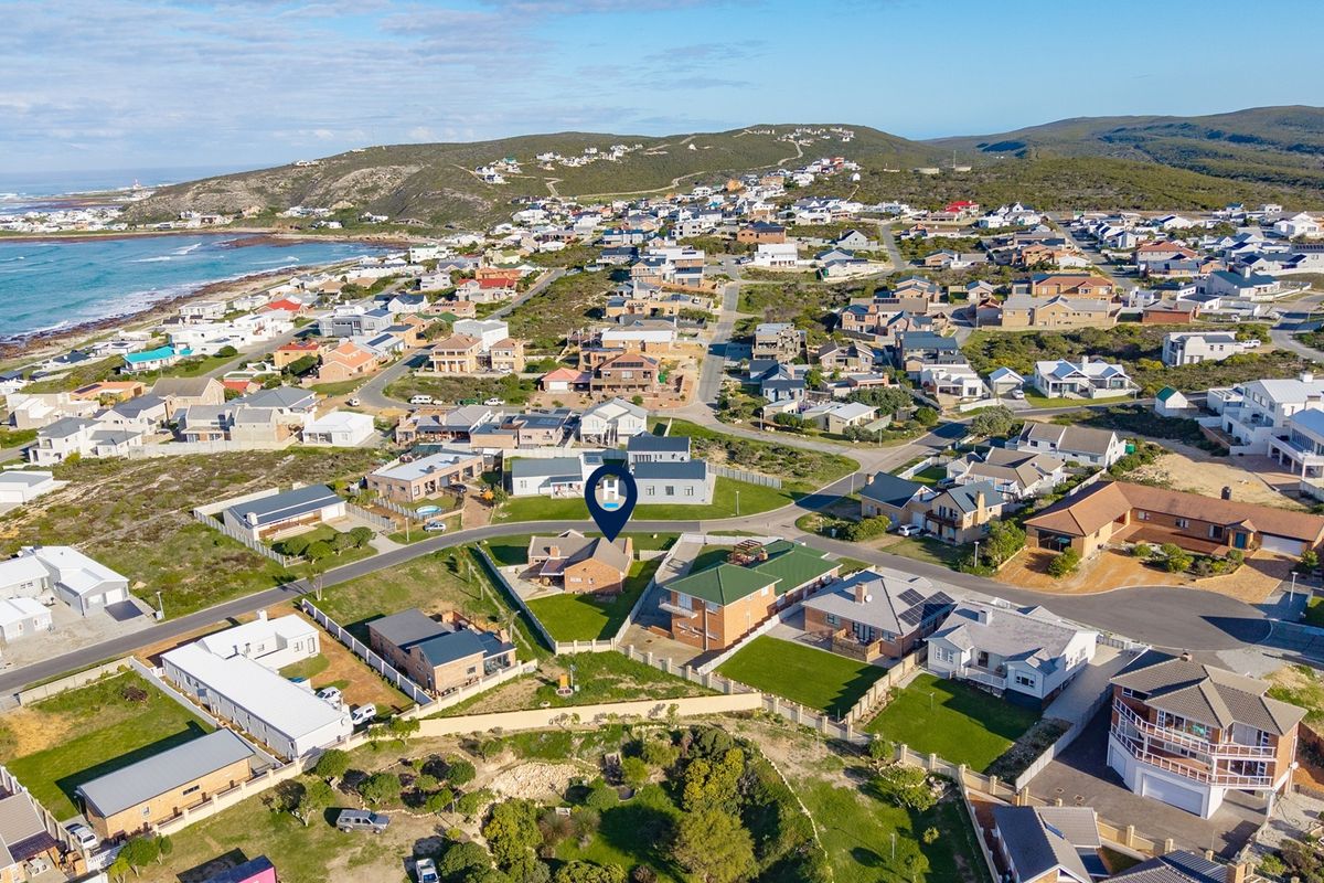An aerial view of the coastal residential neighborhood, highlighting the property's location within the estate and proximity to the coastline.