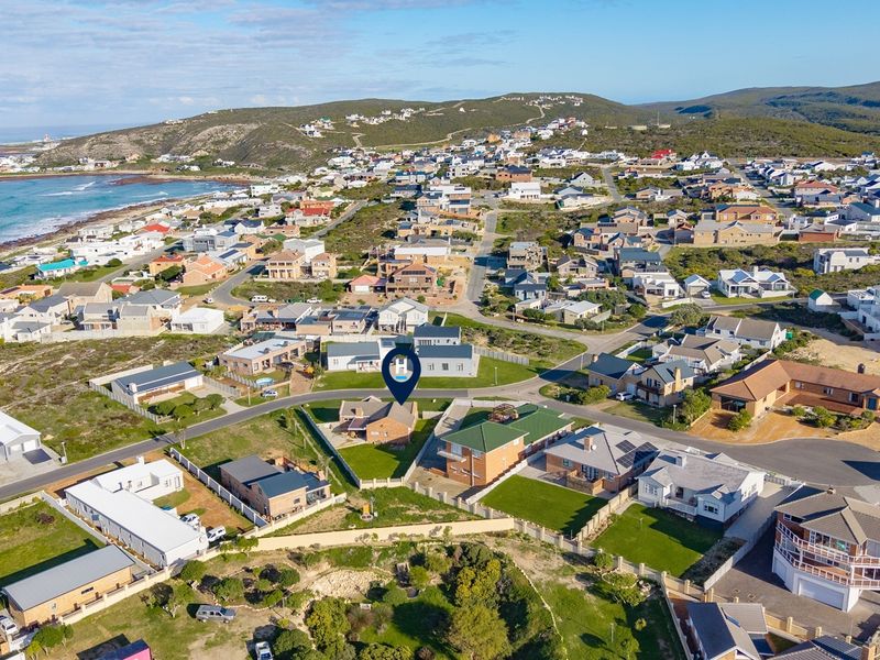An aerial view of the coastal residential neighborhood, highlighting the property's location within the estate and proximity to the coastline.