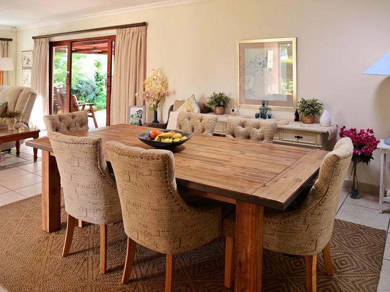 A well-lit dining area featuring tiled flooring and a large sliding glass door providing direct access to the outdoor patio space.