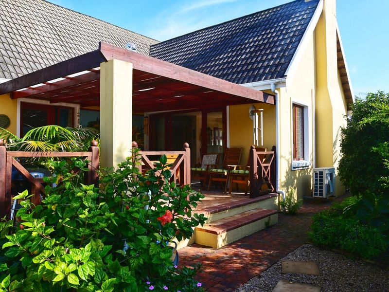 A covered timber pergola patio area with brick paving, featuring a balustrade and direct access to the home's interior.