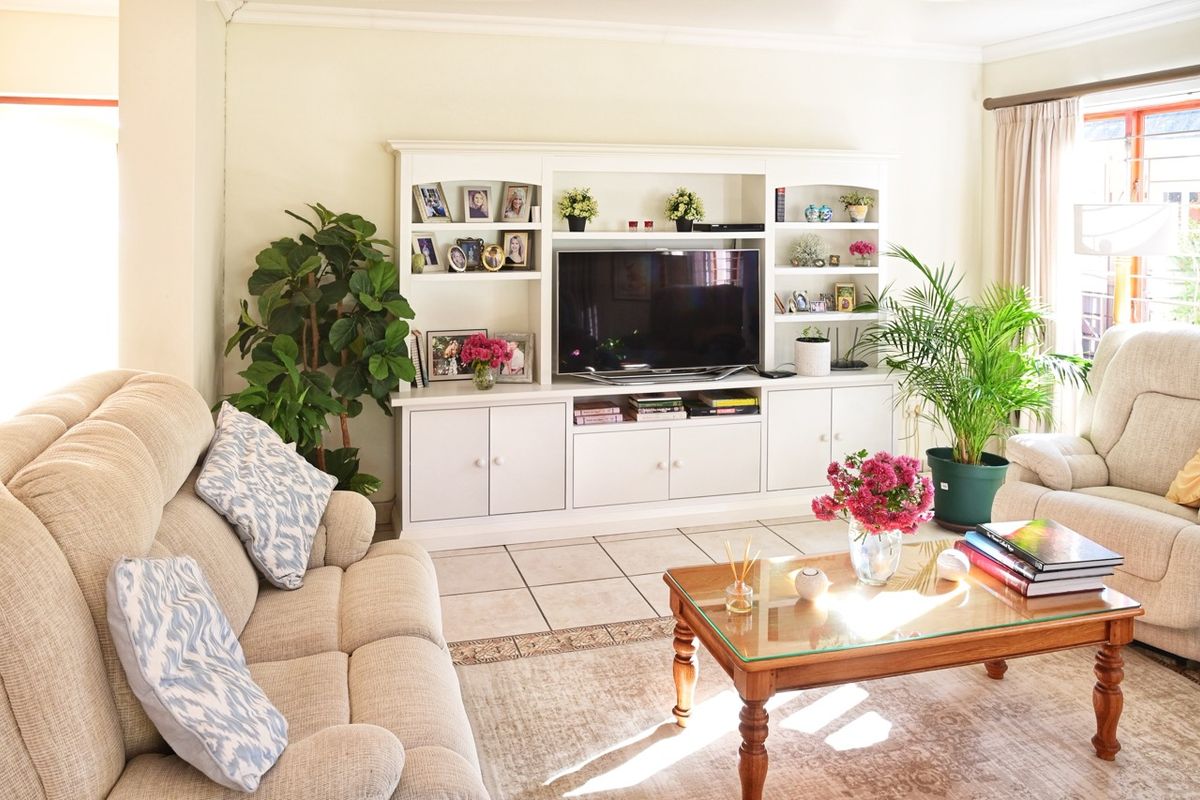 A bright and comfortable living room featuring custom built-in cabinetry and neutral tiled flooring, creating a welcoming space for relaxation.