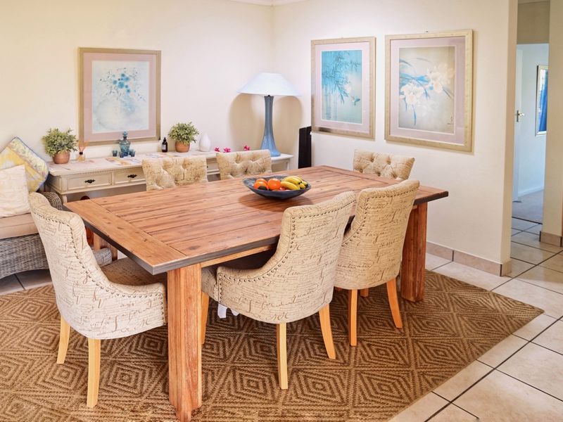 A well-lit dining area featuring neutral tiled flooring and a spacious layout, suitable for family meals and entertaining.
