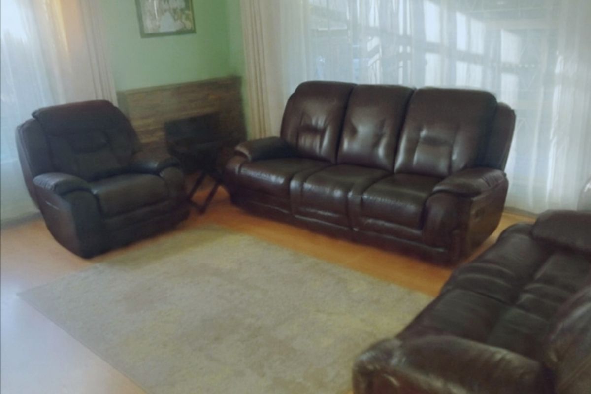 A comfortable living room featuring laminate flooring and a built-in fireplace feature wall, offering a warm and inviting space for relaxation.