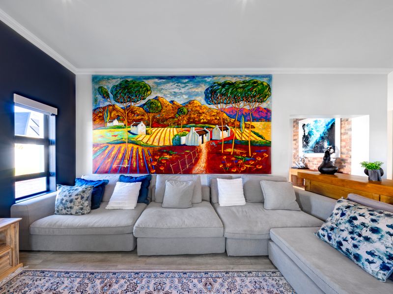 A well-maintained living room featuring a dark accent wall, exposed brick detailing, and modern recessed lighting, creating a warm and inviting atmosphere.