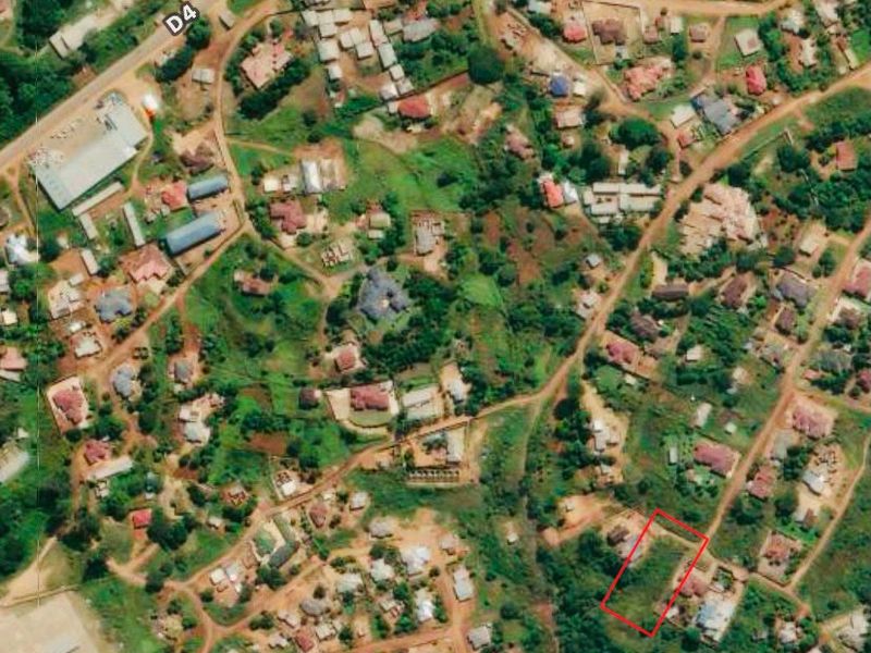 An aerial view of a residential neighborhood highlighting a vacant land plot outlined in red, situated within an established community.