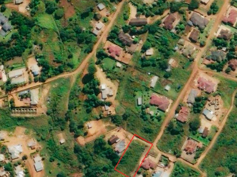 An aerial view highlighting a vacant residential land plot within an established neighborhood setting.