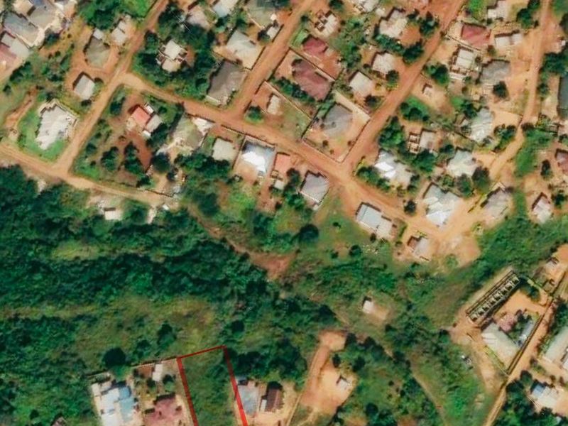 An aerial view of a residential vacant land plot highlighted in red, situated within an established neighborhood.