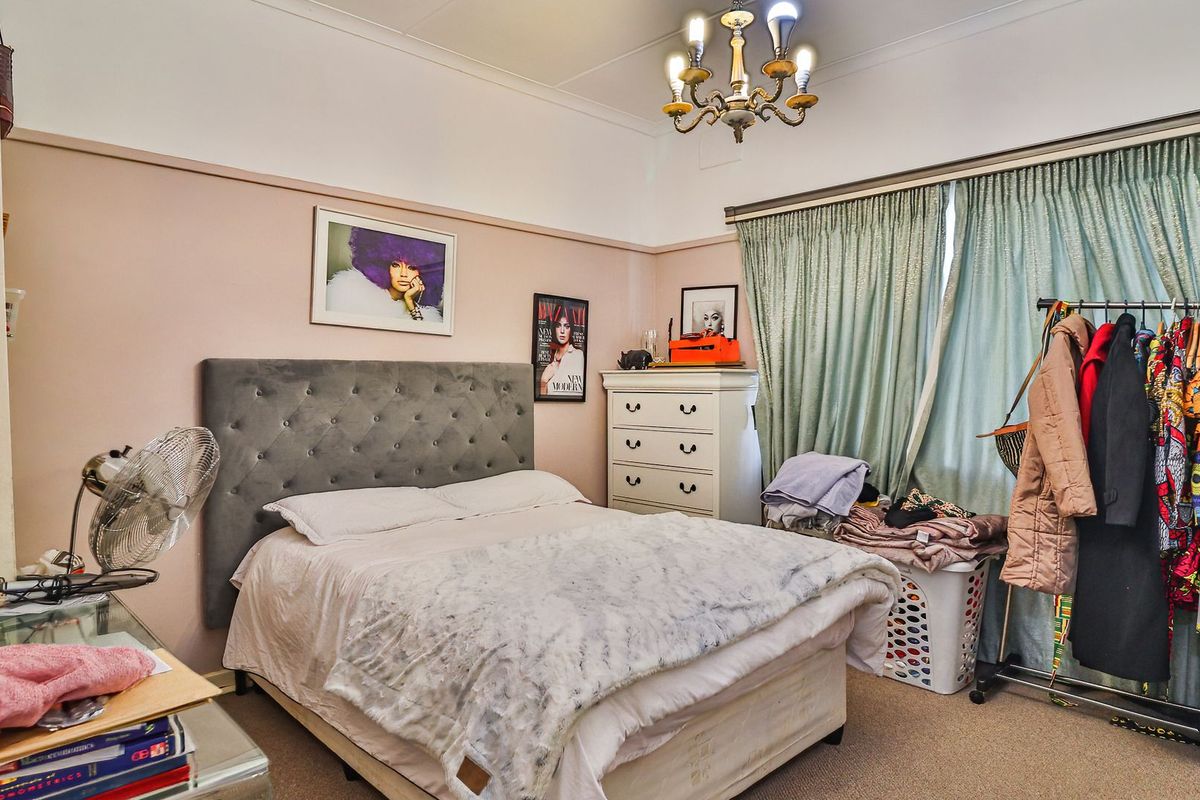A bedroom featuring a coved ceiling, picture rail, and a central chandelier, offering a classic layout with neutral wall tones.