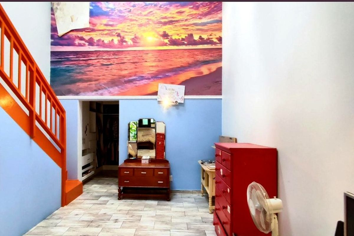 A bedroom featuring a staircase with orange railings, tiled flooring, and a built-in closet area, accented by a large sunset wall mural.
