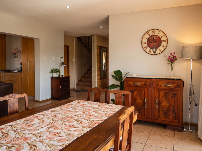 An open-plan dining and kitchen area featuring tiled floors, recessed lighting, and a sliding glass door leading to the exterior.