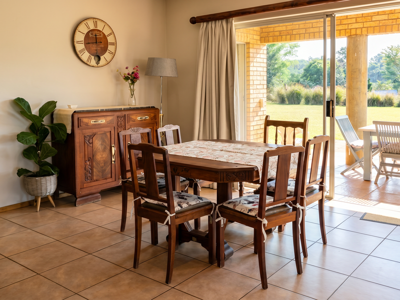 Dining area featuring tiled flooring and large sliding glass doors providing seamless access to a covered patio and garden view.
