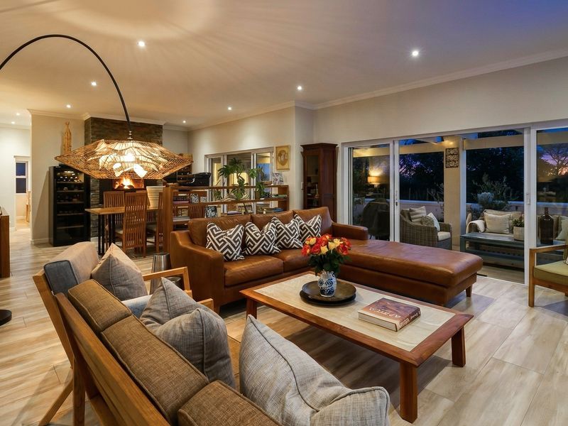 Spacious open-plan living area featuring tiled flooring, recessed lighting, and large sliding glass doors that provide seamless access to the outdoor patio.
