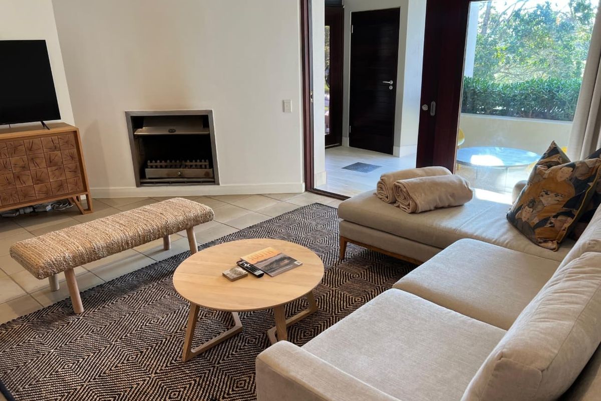A bright living room featuring a built-in fireplace, tiled flooring, and large sliding glass doors that open onto a private patio area.