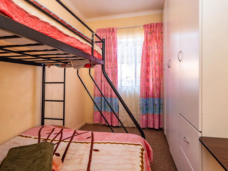 A functional bedroom featuring built-in cupboards and carpeted flooring, providing practical storage and living space.