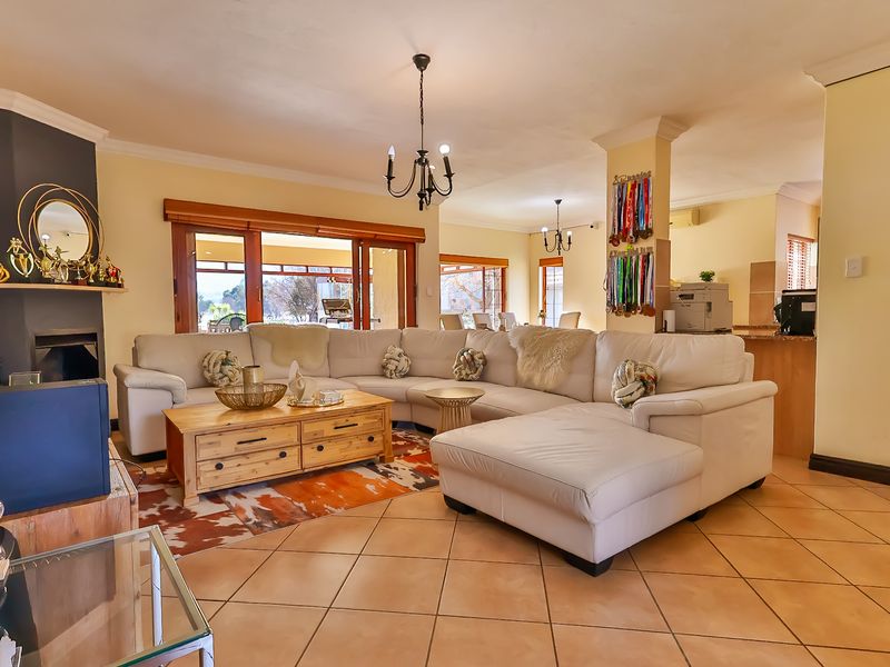 Spacious open-plan living area featuring tiled floors, a built-in fireplace, and large sliding doors providing seamless access to the outdoor patio.