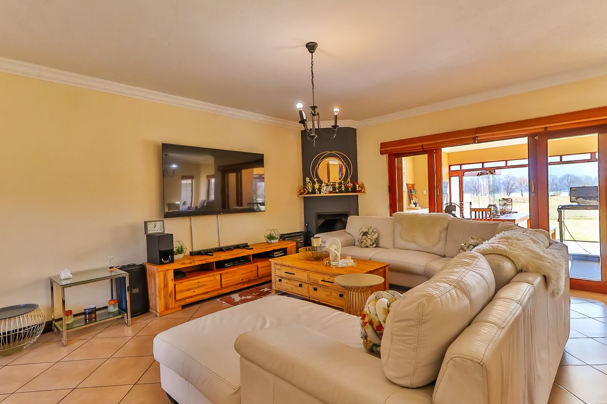 Spacious living room featuring ceramic tile flooring, a central fireplace, and large sliding glass doors providing access to the outdoor area.