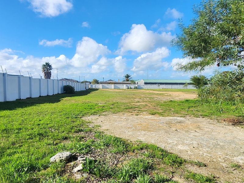 A spacious vacant residential plot featuring a perimeter wall with electric fencing, offering a clear area for future development.