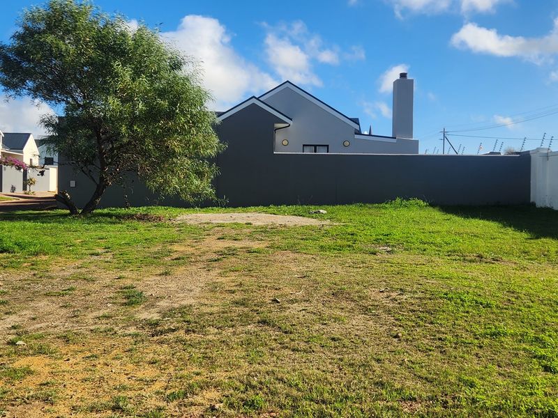 A vacant residential plot featuring established perimeter walls and electric fencing, offering a clear space for future development.