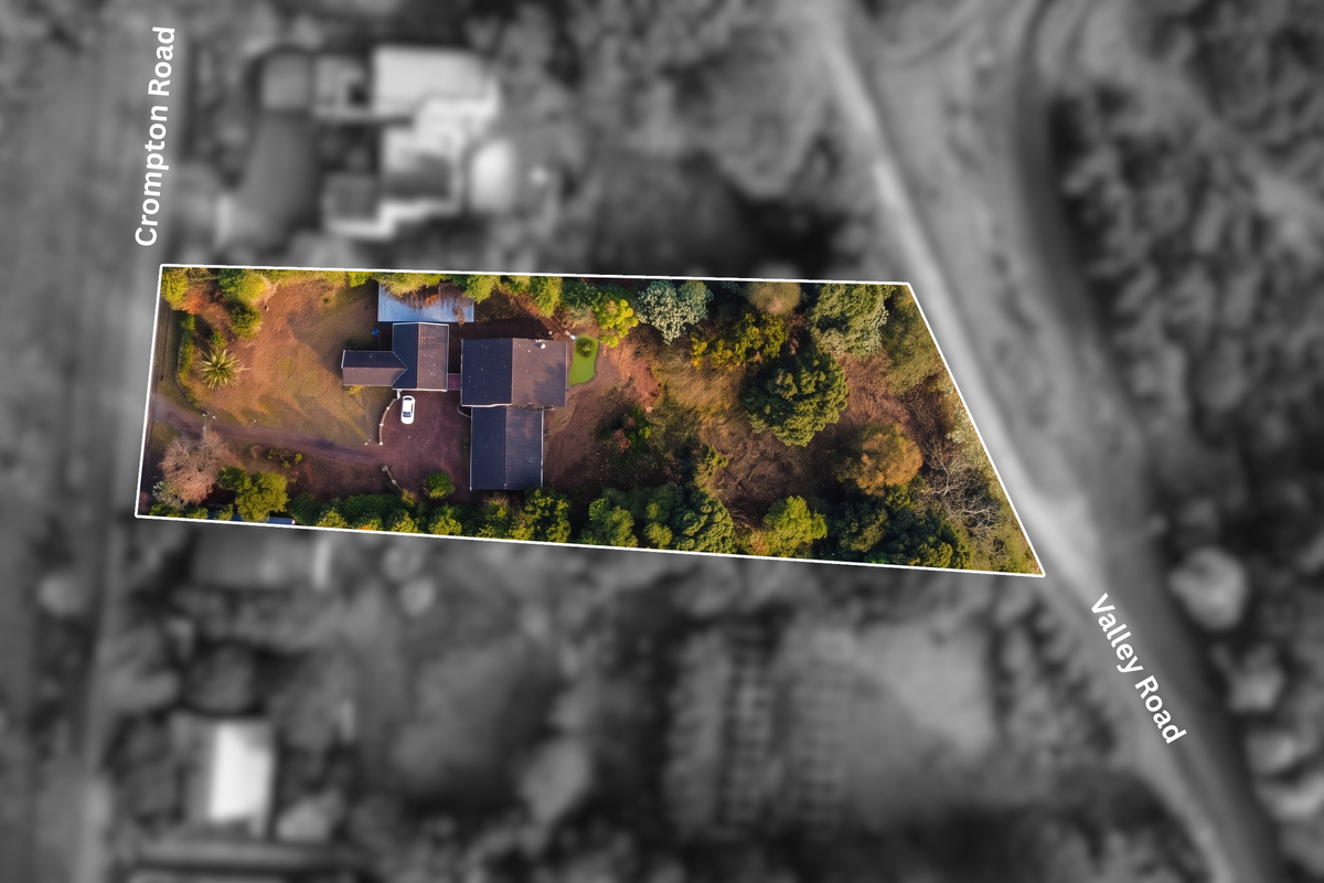 Aerial view of the property showing the house footprint, surrounding garden, and driveway access from the street.