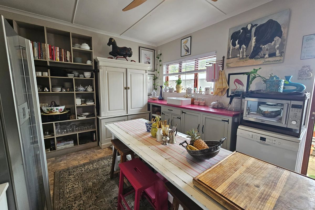 A kitchen featuring built-in cabinetry, a farmhouse-style sink, and open shelving, providing a functional and character-filled culinary space.