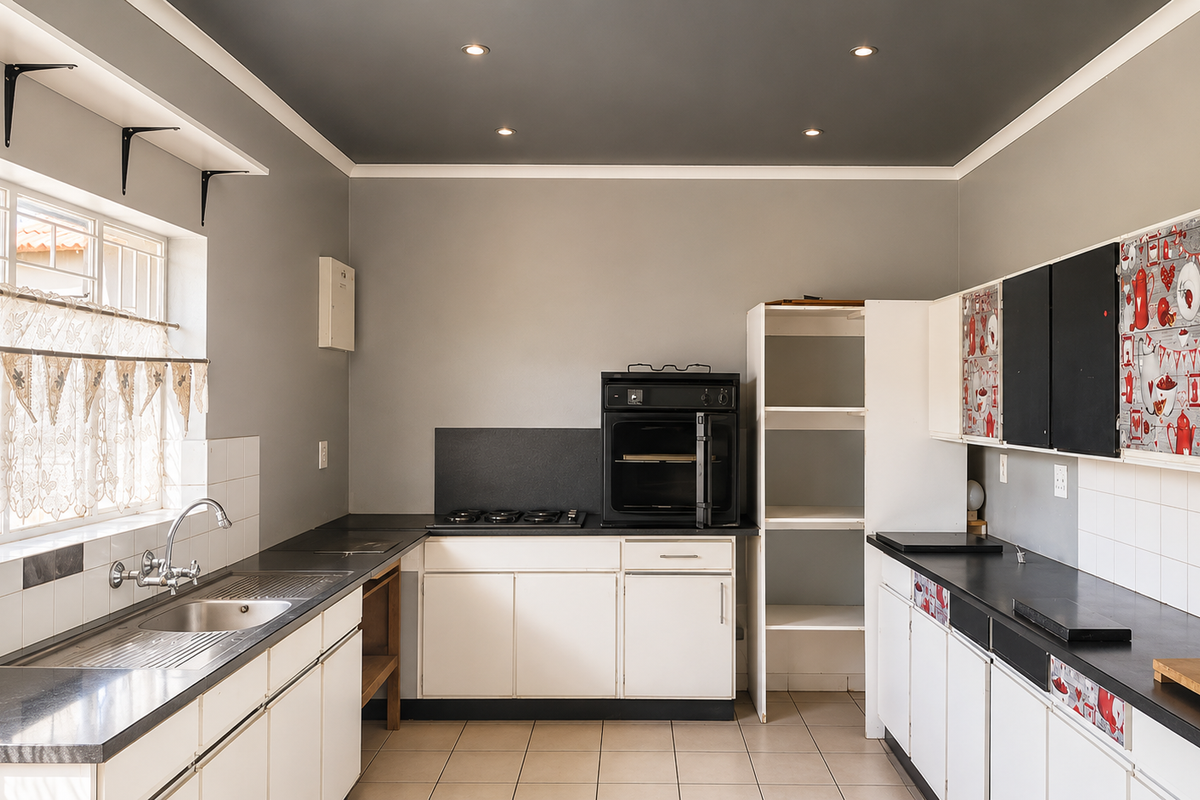 A functional kitchen featuring built-in cabinetry, a stainless steel sink, a gas hob, and an integrated oven with tiled splashbacks and neutral flooring.