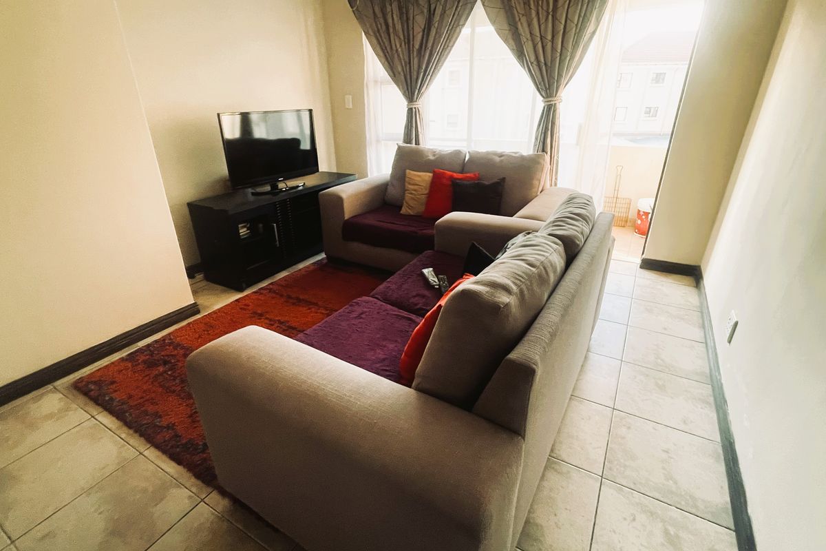 A living room area featuring tiled flooring and a sliding glass door providing access to an outdoor space.