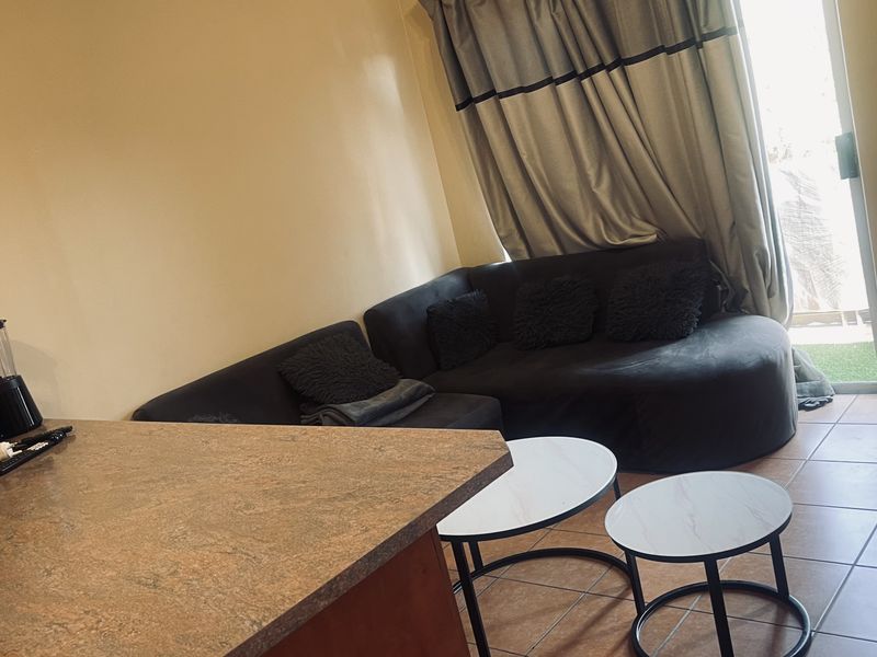 Open plan living area featuring ceramic floor tiles and a sliding glass door providing access to the outdoor space.