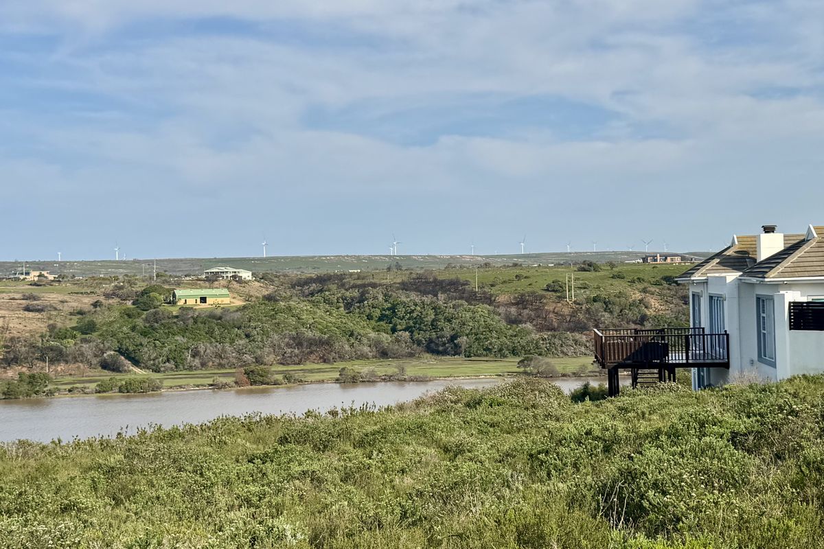 Scenic elevated view overlooking a river and natural landscape, featuring a private wooden deck attached to the residential property.