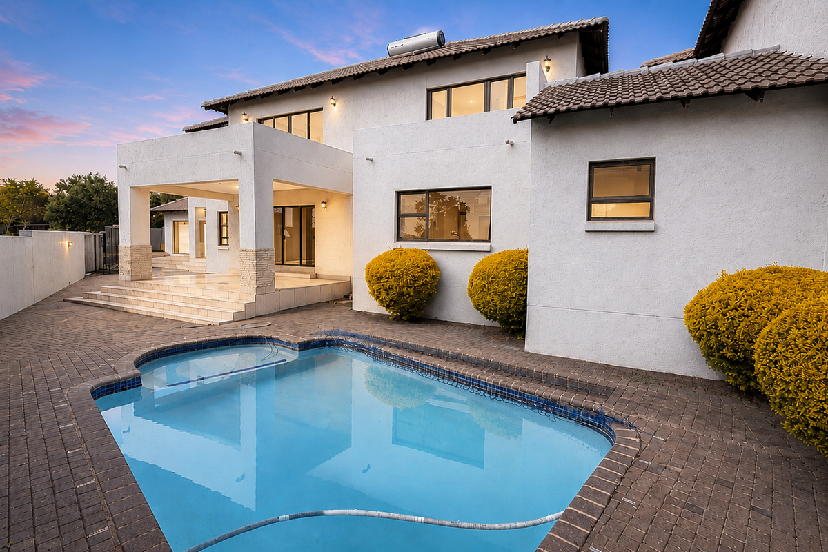 Rear exterior view featuring a swimming pool, paved patio area, and a multi-level residence with a tiled roof and solar water heating system.
