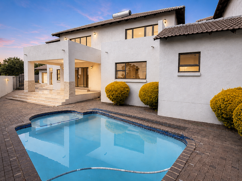 Rear exterior view featuring a swimming pool, paved patio area, and a multi-level residence with a tiled roof and solar water heating system.