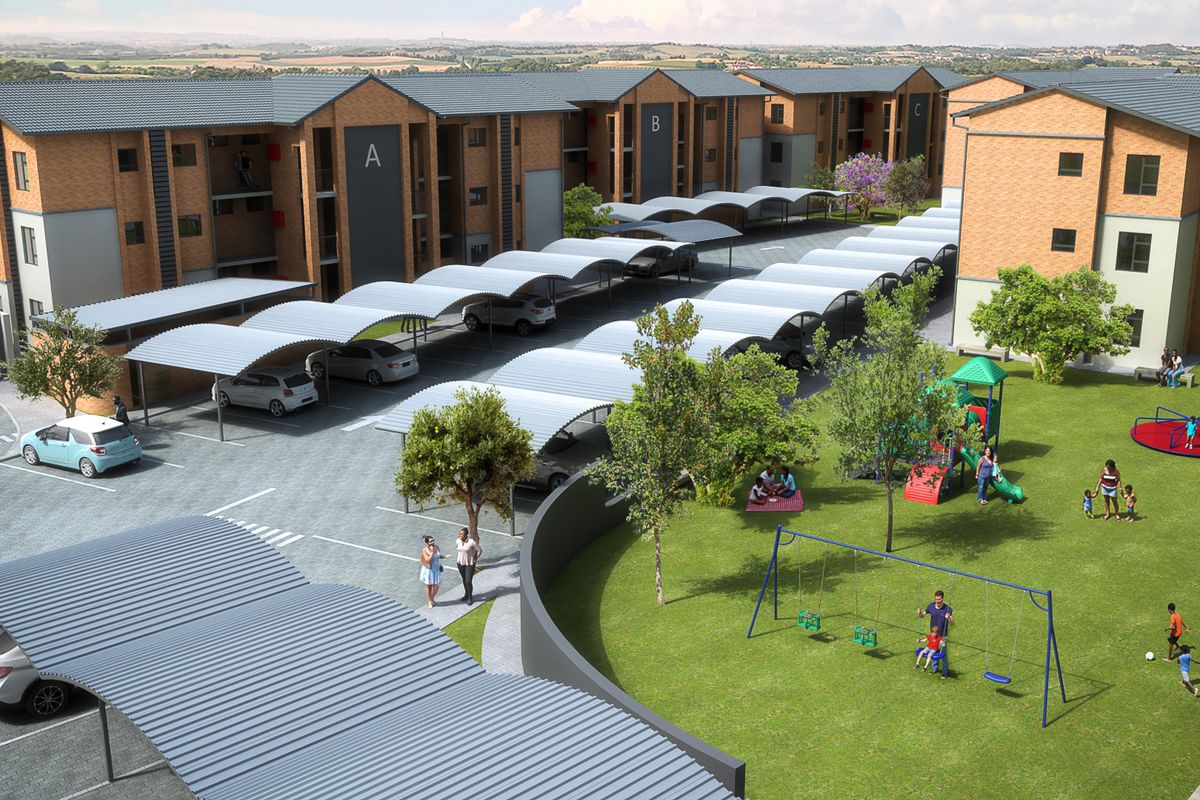 Aerial view of an apartment complex featuring brick buildings, covered parking bays, and a landscaped communal garden with a playground.