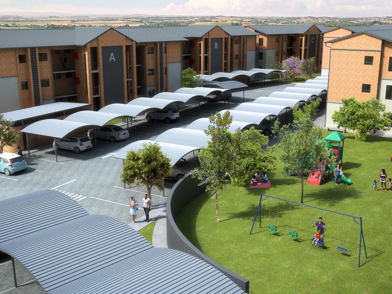 Aerial view of an apartment complex featuring brick buildings, covered parking bays, and a landscaped communal garden with a playground.