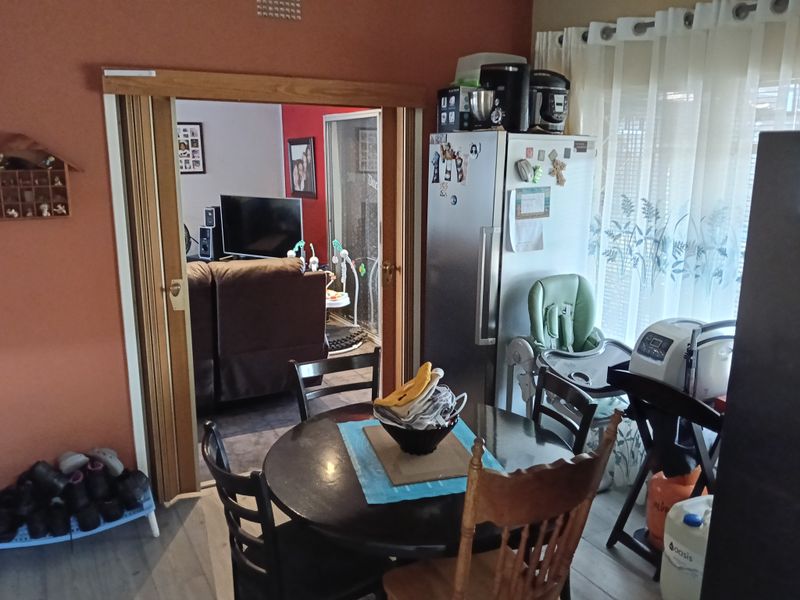 Dining area featuring laminate flooring and a sliding wooden door leading to the adjacent living space.