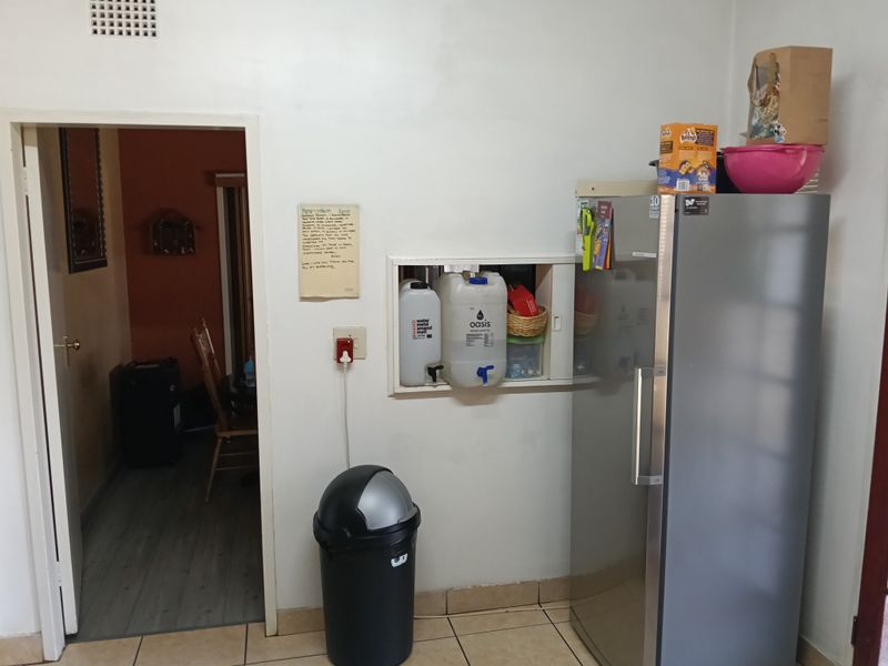 A functional kitchen area featuring tiled flooring and a built-in wall niche, providing a practical space for daily use.