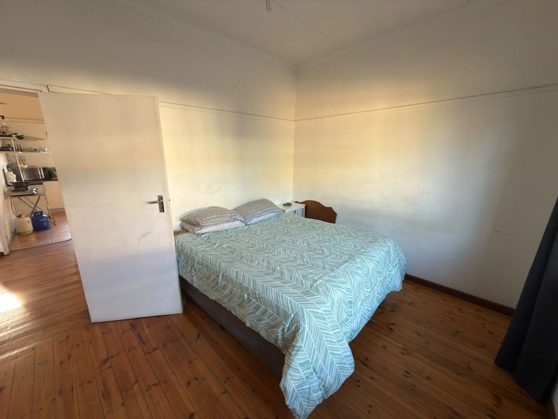 A bedroom featuring original timber flooring and a picture rail, requiring cosmetic updates to the wall finishes to improve the overall aesthetic.