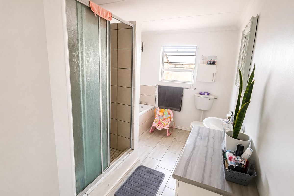 A functional bathroom featuring a separate shower enclosure, bathtub, toilet, and a modern vanity cabinet with a basin.