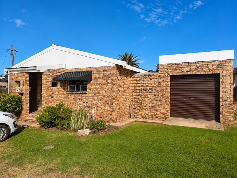 Front elevation of a face brick house featuring a single garage with a roller door and a small front garden area.