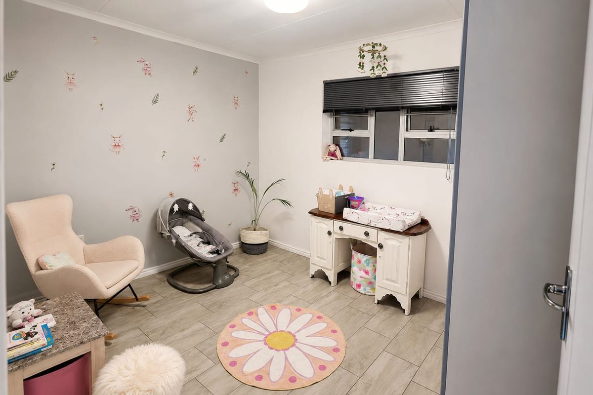 A well-maintained bedroom featuring neutral tiled flooring, a feature wall with decorative decals, and a window fitted with venetian blinds.