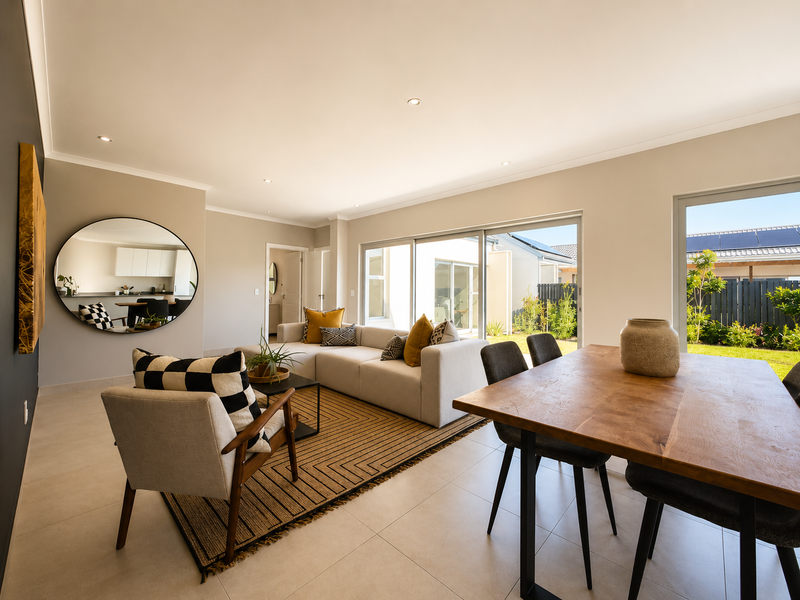 Bright open-plan living and dining area featuring large sliding glass doors that provide seamless access to the rear garden and patio.